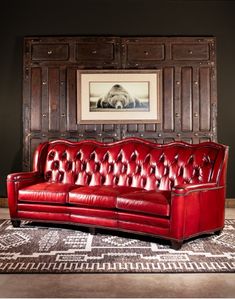 a red leather couch sitting on top of a rug