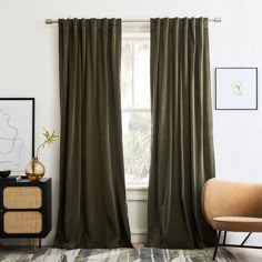 a living room with green curtains and a chair