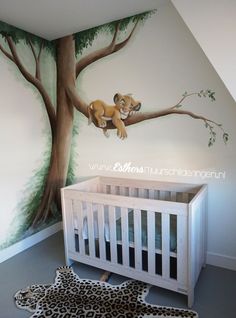 a baby's room with a lion mural on the wall