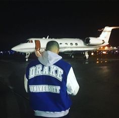 a man standing in front of an airplane at night