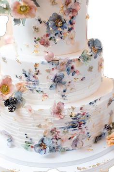 a multi layer wedding cake with flowers on it