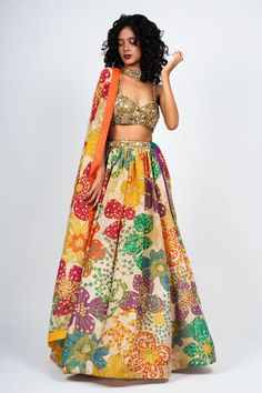 Off white floral printed gathered lehenga with embellished waistband and attached cancan. Comes with embroidered padded bustier and printed dupatta.
Component: 3
Pattern: Print and Embroidery
Type Of Work: Floral print, Beads embroidery
Neckline: Sweetheart
Sleeve Type: Sleeveless
Fabric: Tissue Organza,Tulle
Color: Off White
Other Details: 
Attached lining
Color blocked border dupatta
Note: The neckpiece worn by the model is not for sale
Occasion: Destination Wedding - Aza Fashions Designer Lehanga, Floral Print Lehenga, Sequin Lehenga, Print Lehenga, Lehenga Pattern, Satin Embroidery, Native Dress, Tulle Embroidery, Zardozi Work