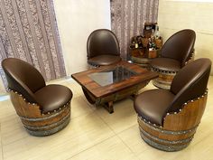 a living room filled with lots of furniture and wooden barrel chairs next to a table