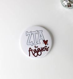 a white button with the word zia on it and a red heart in the middle