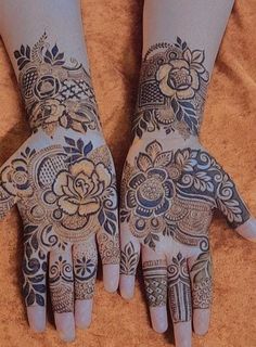 two hands with henna designs on them