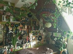 a bedroom with many plants and pictures on the wall above the bed in front of it