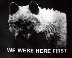 a black and white photo of a dog with the words we were here first