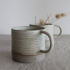 two coffee mugs sitting side by side on a table