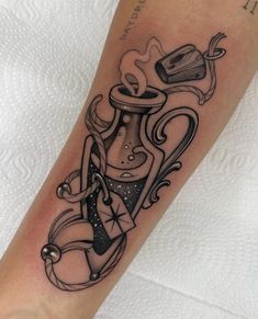 a black and white tattoo on the leg of a woman's arm with an hourglass