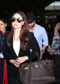 the woman is carrying a brown bag in her hand as she walks through an airport