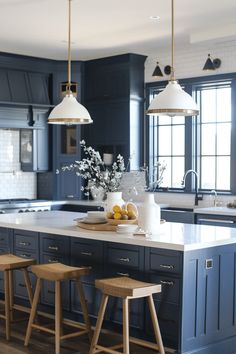 a kitchen with two stools and an island in front of the countertop is painted blue