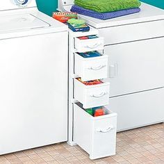 a white washer sitting next to a dryer on top of a tiled floor