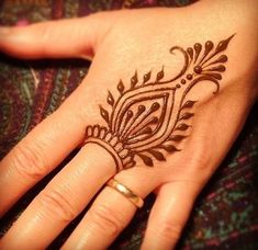 a woman's hand with a henna tattoo on it