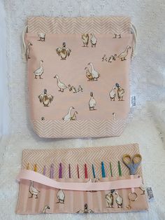 a pink bag with chickens on it next to a pair of scissors and pencils