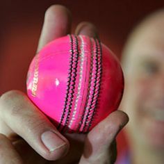 a close up of a person holding a pink ball