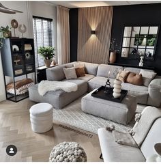 a living room filled with lots of furniture next to a tall window covered in curtains