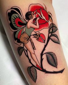 a woman with a flower tattoo on her arm and leg is holding a red rose