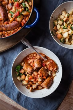 two bowls filled with food on top of a blue cloth next to a wooden cutting board