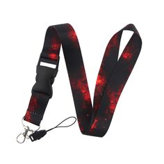 a red and black tie dye lanyard strap with metal snappers on an isolated white background