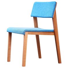 a blue chair sitting on top of a white floor next to a wooden frame structure