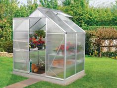 a small greenhouse in the middle of a yard