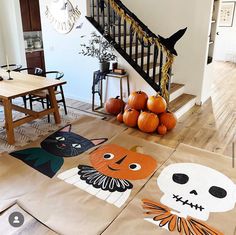 a living room filled with lots of furniture next to a stair case covered in halloween decorations