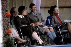 several people sitting on chairs in front of an awning and one person wearing a hat