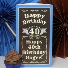 a birthday card with a chocolate cupcake next to it and some paper fans in the background