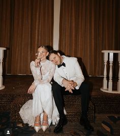 a bride and groom pose for a wedding photo in front of the stage at their reception