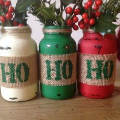 three jars with christmas decorations in them sitting on a table