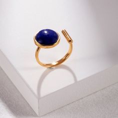 Gemstone: Lapis Lazuli is known for its deep blue color with sparkling flecks of Pyrite. This ancient gemstone symbolizes wisdom and truth.  Metal: High-quality Sterling Silver (S925), offering lightweight, durability, and hypoallergenic properties. Finish: 18K PVD gold-plated finish, ensuring a long-lasting shine and daily wear. Size: Its adjustable comfort feature means this ring adapts to fit sizes 6 to 7.5, offering versatility and ensuring a perfect fit for all. Packaging: Our jewelry arriv Gold Adjustable Minimalist Sapphire Ring, Adjustable Minimalist Gold Sapphire Ring, Adjustable Gold Sapphire Ring In Minimalist Style, Gold Lapis Lazuli Ring As Gift, Gold Lapis Lazuli Ring For Gift, Minimalist Round Lapis Lazuli Jewelry, Minimalist Blue Crystal Birthstone Ring, Elegant Adjustable Lapis Lazuli Ring, Minimalist Blue Crystal Open Ring