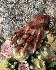 the bride's hands are decorated with henna and flowers for her wedding day