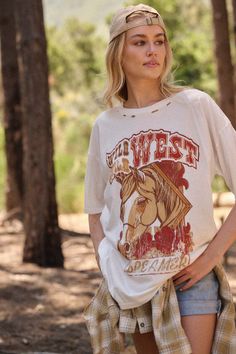 Distressed, garment washed graphic t-shirt. Vintage-style horse graphic with "Wild, Wild West Dreamer" text print. Torn and distressed detailing at neckline, cuffs, and hem. Round neckline. Short sleeves. Drop shoulder. Oversized fit. 100% Cotton. Imported top designed and printed in LA. Model wears size S. Casual Distressed Tops For Rodeo, White Distressed T-shirt For Fall, Oversize Graphic Tee, Horse Graphic, Wild Wild West, Oversized Graphic Tee, Text Print, Iron Decor, Wild West