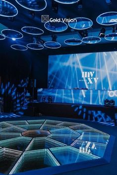 a large screen is shown in the middle of a room with blue lighting and circular lights