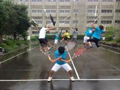 a group of people holding tennis racquets in the air