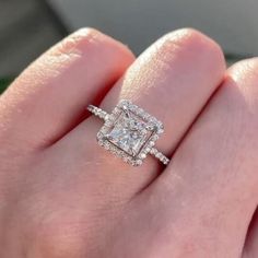 a woman's hand with a diamond ring on top of her finger and an engagement band