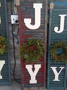 the letters joy, joy and joy are decorated with christmas wreaths on shutters