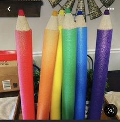 several colored pencils are lined up on a table