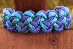 a blue and purple bracelet on top of a wooden post