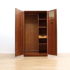 an open wooden cabinet on the floor