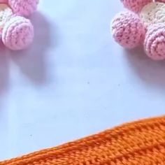 two pink crocheted teddy bears sitting next to each other on a white surface