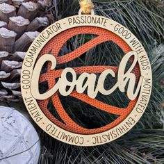 an ornament hanging from a christmas tree with the word coach written on it