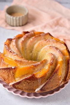 a bundt cake on a pink plate next to a cup