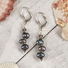 "These dangle earrings feature a beaded drop of cultured Peacock Freshwater Pearls and a sterling silver leverback closure. Peacock pearls dark gray-green undertone with a pink/purple sheen depending on the light. These earrings are 1.25\" long and 3/8\" wide and weigh 5.5 grams. Orders will ship out in 1-3 business days from my Ozark studio. In addition to your jewelry, you'll receive a polishing cloth and silver care instructions card. If you have any questions, please send me a message. I'm happy to help :) ABOUT PROSEBUD -------------------------------------- Prosebud is located in the Arkansas Ozarks and is inspired by art, literature, and vintage aesthetics. Every Prosebud giftbox arrives beautifully packaged with vintage fabric and ribbon. All orders include an art extra, polishing Sterling Silver Drop Pearl Earrings With Lever Back, Silver Dangle Beaded Earrings With Pearl Drop, Silver Beaded Earrings With Pearl Drop, Silver Earrings Wedding, Peacock Pearls, Clean Sterling Silver, Peacock Pearl, Trending Jewelry, Rose Violette