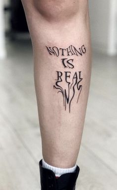 a person with a tattoo on their leg that says nothing is real and the words are written in black ink