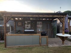 a backyard with a bar and grill in the back yard, next to a fence