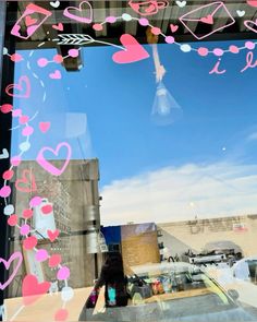 the window is decorated with pink and blue hearts, as if it were in love