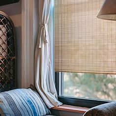 a window seat with pillows and a lamp next to it