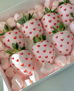 a box filled with lots of white chocolate covered strawberries and hearts on top of marshmallows