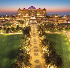 an aerial view of the resort at night with palm trees and lawns in front